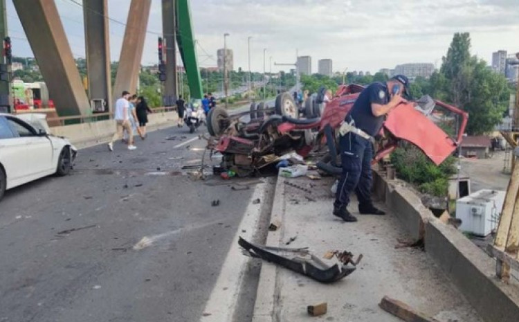 Smrskani dijelovi kamiona i BMW-a rasuti po putu, dio vozila visi preko ograde mosta